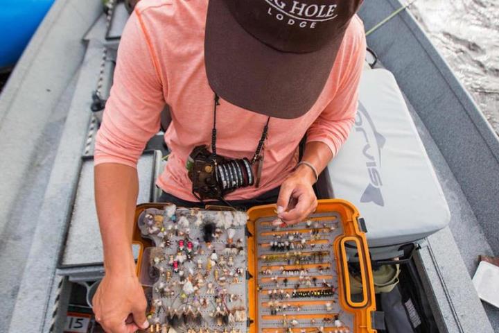 Person handling box of fly fishing flies